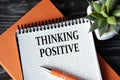 THINKING POSITIVE - words in white notebook on dark wooden background with cactus and pen Royalty Free Stock Photo