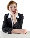 Thinking redhead businesswoman sitting at desk Royalty Free Stock Photo