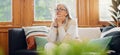 Thinking, reflection and senior woman on sofa in the living room with memory or dreaming face. Relax, idea and elderly Royalty Free Stock Photo