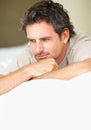 Thinking, relax and mature man in bed in the morning after nap, break or comfortable sleep at home. Smile, idea and male Royalty Free Stock Photo