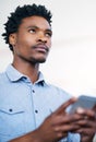 Thinking of the right words...a handsome young businessman sending a text message.