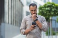 Thinking and sad muslim businessman reading message from smartphone, man outside office building using phone depressed Royalty Free Stock Photo