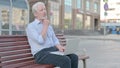 Thinking Old Man Using Laptop while Sitting Outdoor on Bench Royalty Free Stock Photo