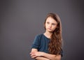 Thinking serious cute kid girl looking up with long curly hair and folded arms on grey studio dark background with empty copy Royalty Free Stock Photo