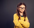 Thinking serious kid girl with folded arms in eyeglasses looking on grey studio background. Back to school. The concept of Royalty Free Stock Photo