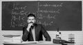 Thinking on serious problem. Serious teacher touching beard by hand. Bearded man with serious face sit at teachers table Royalty Free Stock Photo