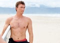 Thinking, serious and shirtless man with surfboard on beach in wetsuit for sports, travel or fitness. Nature, vision and Royalty Free Stock Photo