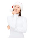 Thinking and smiling woman in santa helper hat