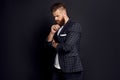 Thinking about something. Upset man with long hair and beard standing against grey background