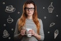 Beautiful woman drinking tea and thinking about eating sweets Royalty Free Stock Photo