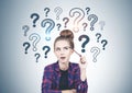 Thinking teen girl question marks on grey wall Royalty Free Stock Photo