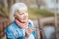Serious old woman holding her glasses Royalty Free Stock Photo