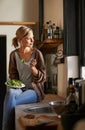 Thinking, woman and eating salad in kitchen at home, nutrition and fresh leafy greens for healthy diet. Food, bowl and Royalty Free Stock Photo