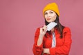 Thinking woman holding phone. Photo of cheerful cute beautiful young woman chatting by mobile phone isolated over pink wall