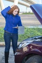 Thinking woman with opened car cowling