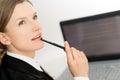Thinking woman presenting laptop screen and pen Royalty Free Stock Photo