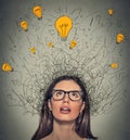 Thinking woman with question signs and light idea bulb above head looking up Royalty Free Stock Photo