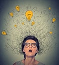 Thinking woman with question signs and light idea bulb above head looking up Royalty Free Stock Photo