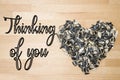 Thinking of you - card. Heart lined with husks of sunflower seeds on a background of beech wood. Royalty Free Stock Photo