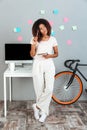 Thinking young african woman standing near computer Royalty Free Stock Photo