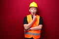 Thinking Young asian man worker is seriously think gesture on red background Royalty Free Stock Photo