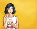 Thinking young sexy woman  looking up on empty space  with smartphone.Pop Art girl is thought and holding hand near the face Royalty Free Stock Photo