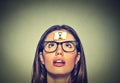Thinking young woman with sand clock sign sticker on her forehead Royalty Free Stock Photo