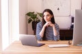 Thinking young woman using laptop and computer while working from home Royalty Free Stock Photo