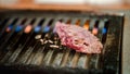 Thinly sliced Japanese wagyu beef on grille for barbecue. Yakiniku style