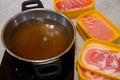 Thinly sliced of raw pork on yellow tray with hot soup in pot prepare for customer cook Royalty Free Stock Photo