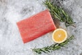 Thinly sliced raw salmon steak with rosemary sprigs and a lemon wedge on a bed of ice Royalty Free Stock Photo