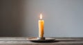 Third Advent candle burning on a rustic wooden table.