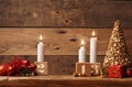 Third Advent candle burning on a rustic wooden table