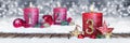 third sunday of advent red candle with golden metal number one on wooden planks in snow front of silver bokeh background Royalty Free Stock Photo
