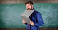 Thirst of knowledge. Teacher bearded man bites modern laptop chalkboard background. Hipster teacher wear eyeglasses and Royalty Free Stock Photo