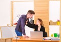 A thirst for romance. Couple of young coworkers conducting office romance. Workplace romance of handsome man and sexy Royalty Free Stock Photo