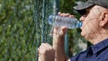 Thirsted Person Back of a Metallic Fence Drinking Water