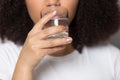 Thirsty African American girl drinking clean mineral water close up