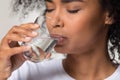 Thirsty African American woman drinking clean mineral water close up Royalty Free Stock Photo