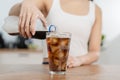 Thirsty, asian young woman, girl holding, pouring cold cola soft drink soda, sparkling water with ice sweet sugar from bottle Royalty Free Stock Photo