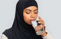 Thirsty black muslim woman in hijab drinking mineral water from glass Royalty Free Stock Photo