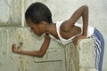 Thirsty Brazilian boy trying to catch water droplets