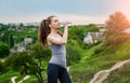 Thirsty fitness girl holding bottle of water