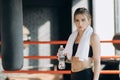 Thirsty fitness woman resting taking a break with water bottle drink inside after training Royalty Free Stock Photo