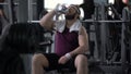 Thirsty happy man drinking water after exhausting training, weight loss workout