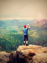 Thirsty hiker in blue and black sportswear drinking water from plastic bottle. Sweaty tired tourist