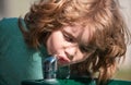 Thirsty kids. Close up head shot of child drinking water outdoor in park. Kids face, little boy portrait. Royalty Free Stock Photo