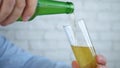 Thirsty Man Filling a Glass with Cold and Fresh Beer from a Bottle