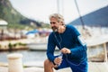 Thirsty senior man drinking water before running. Active old man having a break during his jog routine outside Royalty Free Stock Photo