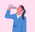 Thirsty woman drinks refreshing water from bottle